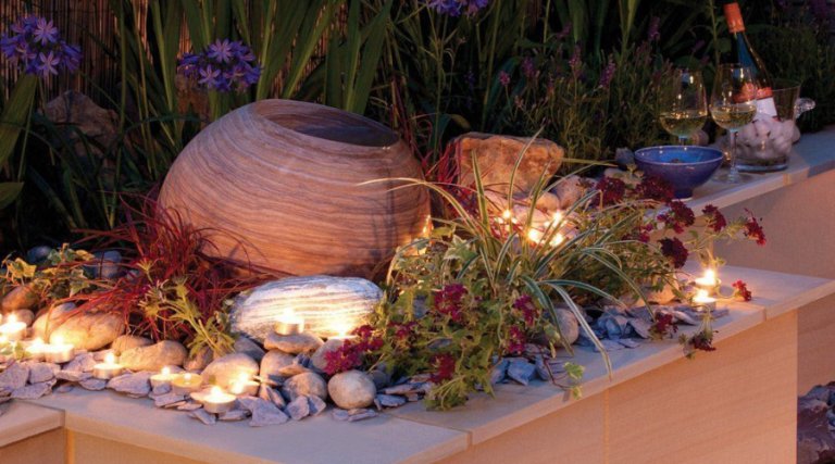 Sandstone sphere water feature integrated into a raised planted border