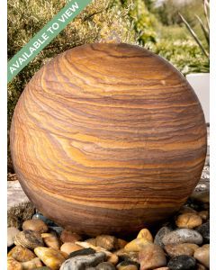 Rainbow sandstone sphere water feature positioned as a garden focal point